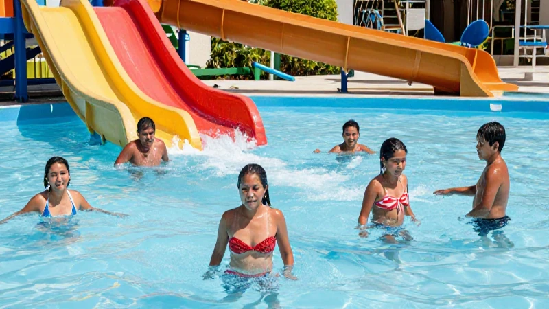 Familias disfrutan toboganes de agua al sol